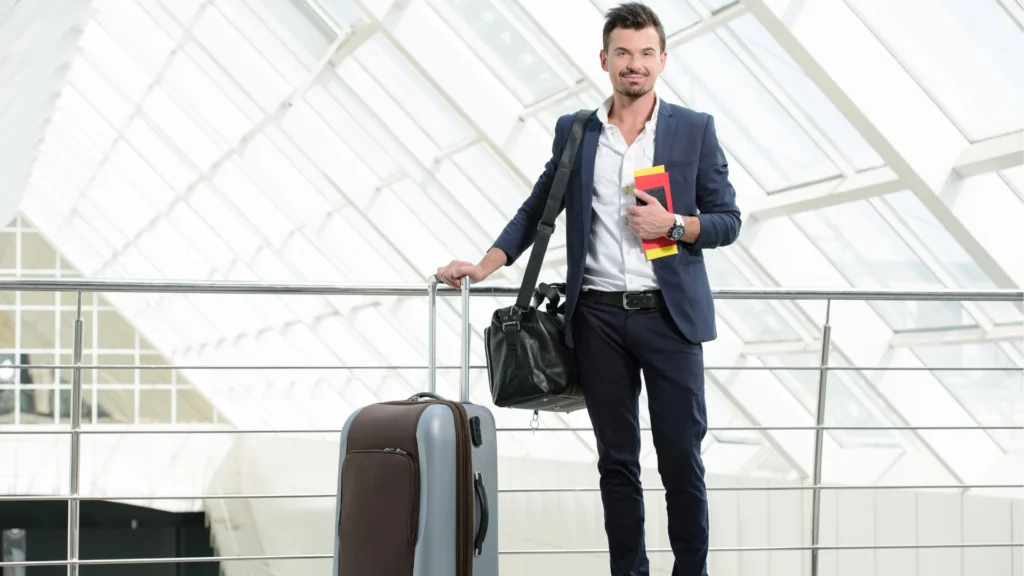 Homme en costume souriant avec valise et passeport